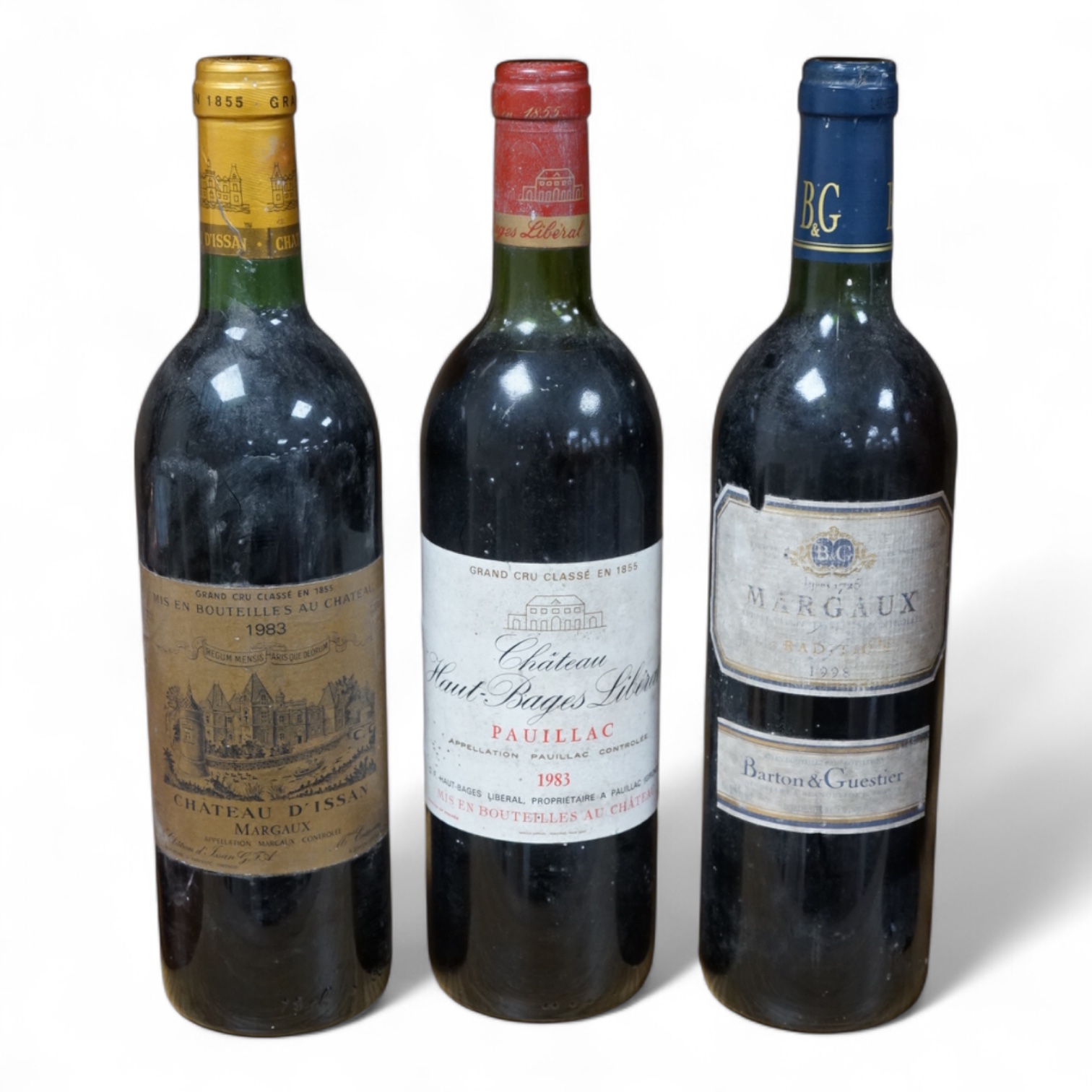 Three bottles of red wine: Chateau D’Issan Margaux 1983, Chateau Haut-Bages Liberal 1983 and Margaux 1998. Condition - good